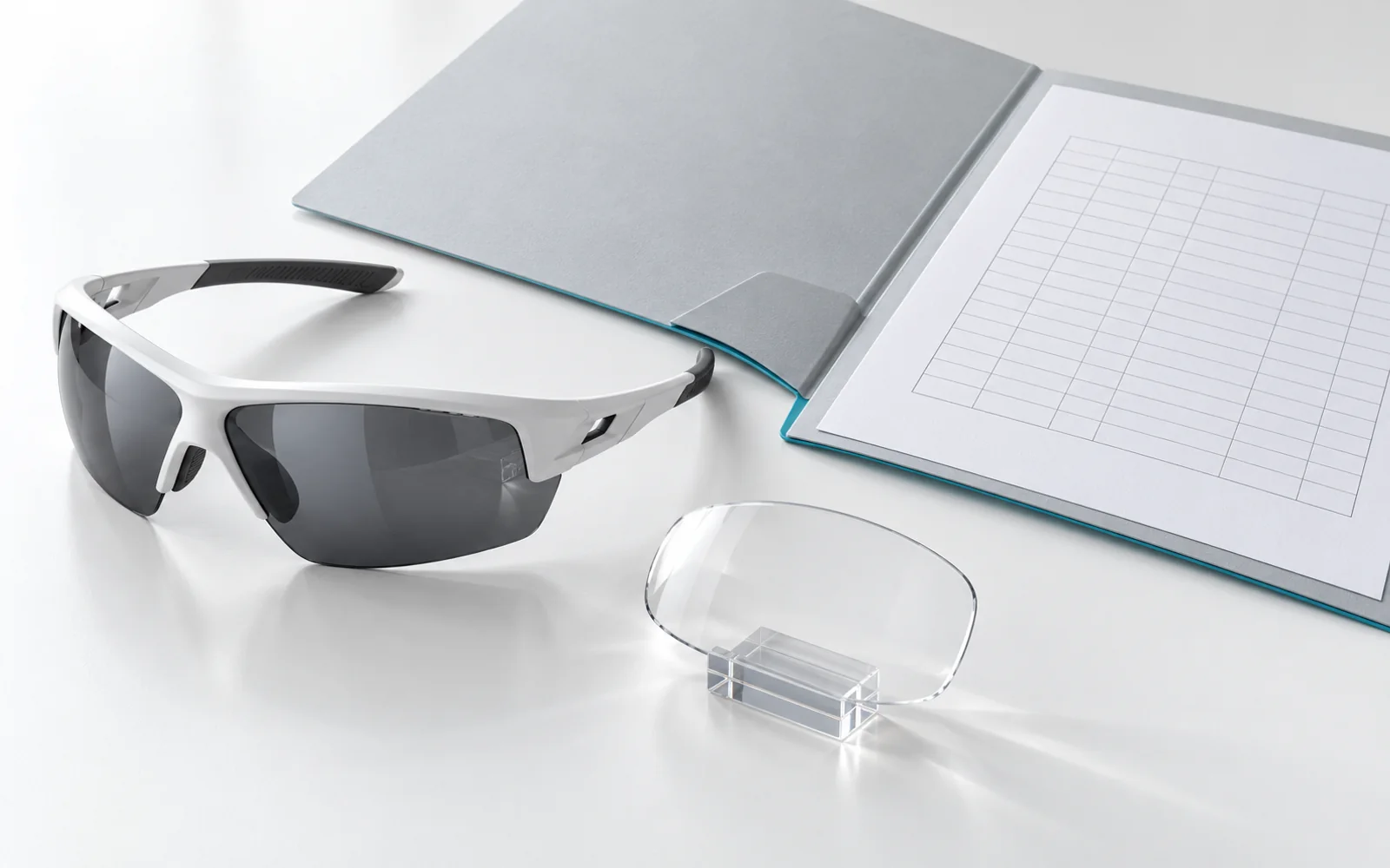 A sports sunglass lens and frame alongside a document folder and optical samples